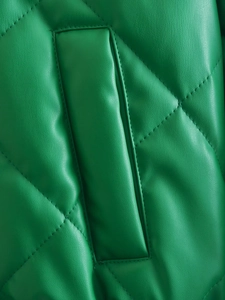 Close-up of green quilted faux leather material with classic diamond stitching detail