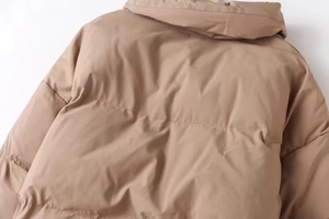 Detail of khaki hooded puffer coat featuring horizontal quilting and premium insulation