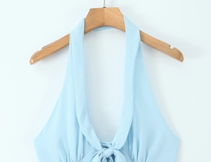 Close-up of light blue halter neck top with V-neckline and decorative bow tie detail