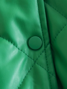 Close-up of green faux leather jacket with diamond quilting and matching button detail