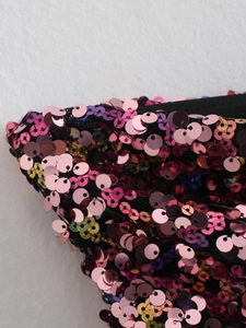 Close-up of vibrant gradient sequins on a chic Y2K party top with metallic finish