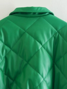 Close-up of green PU leather quilted jacket showing detailed diamond stitch patterns
