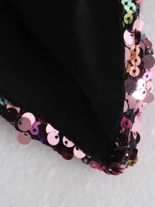 Detail of pink sequins on black knit top with reflective circular metallic finish