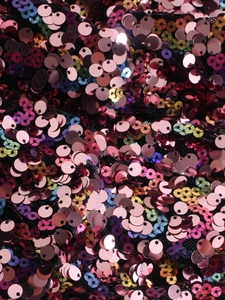 Macro close-up showing iridescent pink and gold sequins on a black mesh base material
