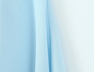 Close-up of light blue chiffon fabric showing granular texture and soft draped pleats