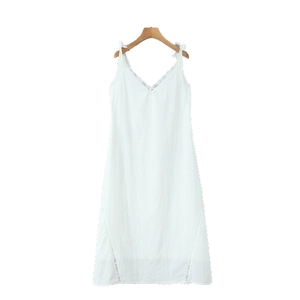 Close-up of V-neck lace trim and shoulder bow details on a white summer slip dress