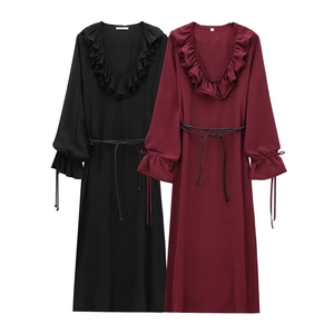 Détail du col en V à volants et taille à cordon sur robes noires et rouge bordeaux