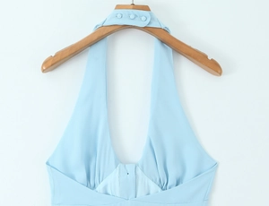 Detail of light blue halter neck top with triple button closure and deep V-neckline