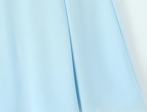 Macro detail of light blue chiffon fabric showing fine texture and vertical drapes