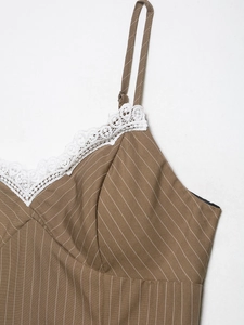 Detail of V-neckline with delicate white lace trim on brown striped dress with straps