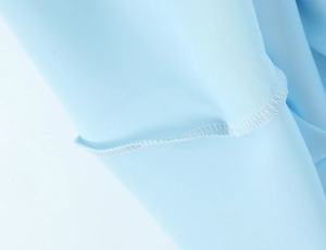 Detail of light blue chiffon dress showing high-quality fine hem stitching and fabric texture