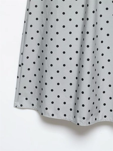 Close-up of light grey polka dot skirt fabric showing premium stitching and drape