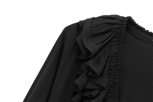 Détail d'une robe noire avec tissu froncé élastique et manches à volants superposés