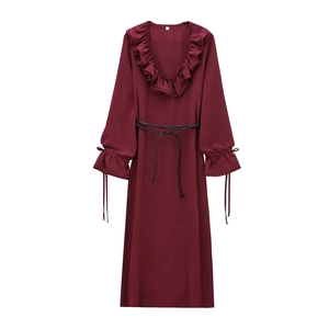 Détail de la robe bordeaux à col en V avec volants et fine ceinture noire
