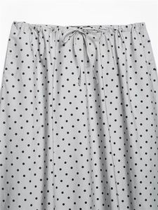 Close-up of elastic waist with drawstring and black polka dot pattern on grey skirt