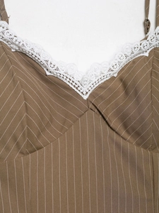 Detailed close-up of brown striped V-neckline with delicate white lace trim and thin straps