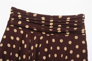 Detailed view of brown polka dot skirt featuring pleated waist and side invisible zipper