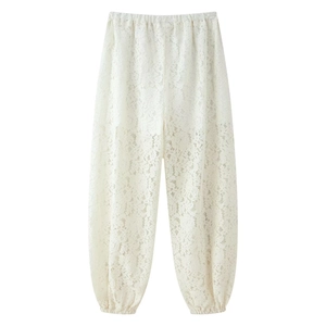 Detalle de la textura de encaje floral blanco y cintura elástica de los pantalones