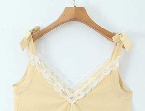 Detail of V-neck lace trim and shoulder tie bow on cream summer dress