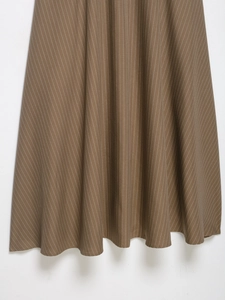 Close-up detail of brown vertical striped fabric and high-quality stitching on a skirt