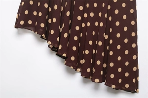 Detail shot of asymmetric hemline on a dark brown polka dot chiffon skirt for women