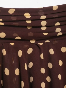 Detailed close-up of dark brown chiffon fabric with large beige polka dots and pleated texture