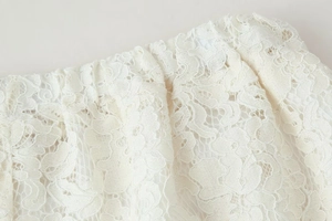 Primer plano de los detalles de encaje floral blanco en la cintura elástica del pantalón