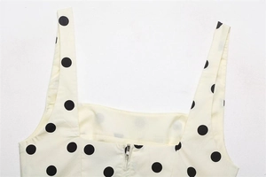 Detailed close-up of square neck and wide straps on a polka dot crop top with back zipper