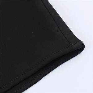 Gros plan des coutures à double aiguille et du tissu sergé sur la robe noire