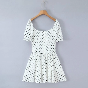 Detail von Karree-Ausschnitt und kurzen Faltenärmeln am weißen Polka-Dot-Kleid