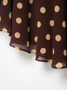 Close-up of brown chiffon fabric with beige polka dots and delicate hem stitching detail