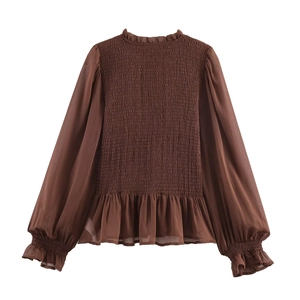 Detail of smocked texture and ruffle stand collar on a vintage French brown blouse