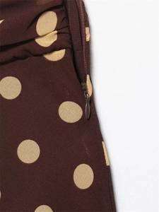 Detail of polka dot chiffon fabric with seamless side zipper on a retro brown skirt