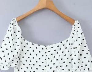 Detailansicht der weißen Polka-Dot-Bluse mit quadratischem Ausschnitt und Puffärmeln