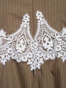 Detail of coffee brown striped fabric with delicate white lace floral embroidery applique