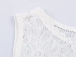 Close-up of white floral lace neckline with delicate scalloped edges and mesh texture