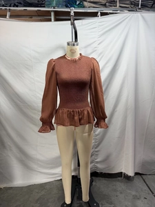 Detail of French vintage smocked brown blouse featuring ruffle stand collar and layered hem