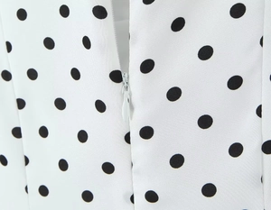 Detailaufnahme von weißem Polka-Dot-Stoff mit hochwertigem verdecktem Reißverschluss hinten