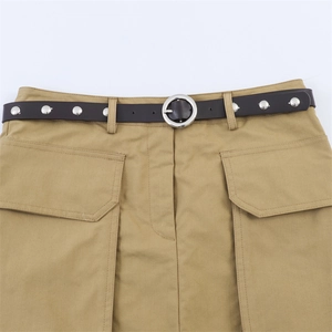 Détail de la taille d'une jupe cargo kaki avec ceinture en cuir noir et rivets argentés