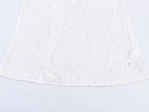 Detailed close-up of white crochet lace fabric with intricate hollow patterns and texture