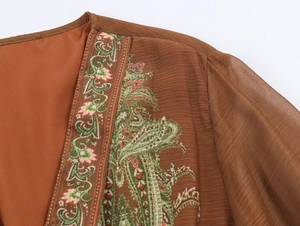 Detail of bohemian paisley embroidery on semi-sheer brown chiffon vintage dress