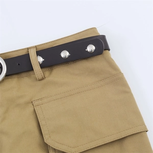 Détail de la jupe cargo kaki avec ceinture à rivets métalliques et grande poche plaquée