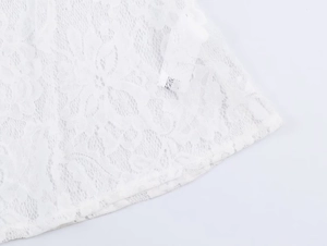 Detail of white floral lace fabric with intricate cutout patterns and high-quality stitching