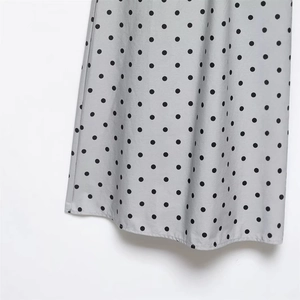Polka dot short skirt for women featuring black dots on light gray flowing fabric
