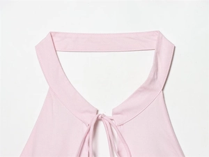 Détail du haut dos nu rose clair montrant les fines bretelles et le tissu élastique lisse