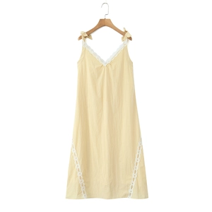 Pale yellow V-neck dress with white lace trim and adjustable bow straps on a white background