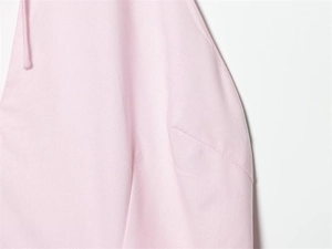 Détail du tissu rose clair de la robe avec coutures nettes et une fine bandoulière