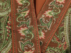 Close-up of paisley pattern on brown linen fabric with intricate bohemian floral details
