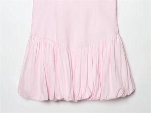 Détail d'une robe rose clair avec ourlet bulle et plis froncés pour un effet volumineux