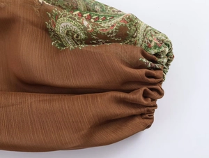 Detail of bohemian paisley print on lightweight fabric with elegant elastic ruching